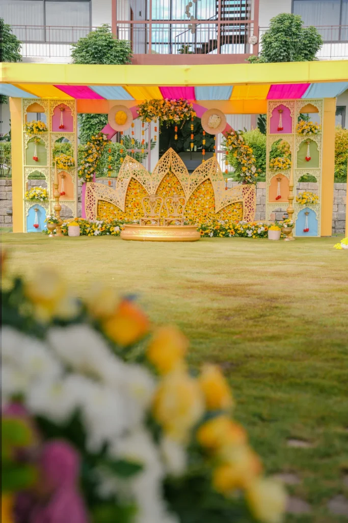 Full view of colourful Haldi ceremony stage with lotus-inspired backdrop and floral decorations